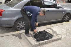 На вул. Ватутіна біля будівлі Чернівецької ОДА ложками засипають пеньки На вул. Ватутіна біля будівлі Чернівецької ОДА ложками засипають пеньки